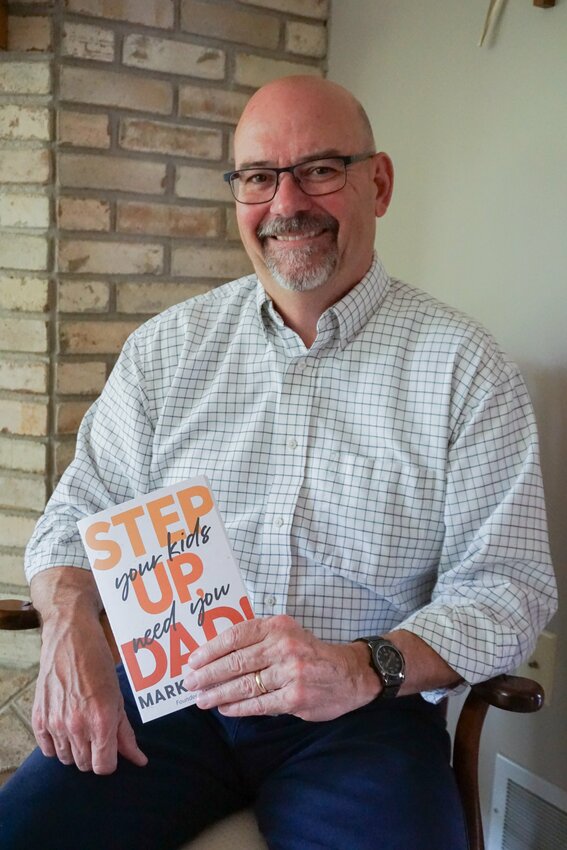 Author Mark Berchem is photographed showing a copy of his book, &quot;Step up, Dad: Your Kids Need You,&quot; published in Feb., 2023 by Wellspring Books.