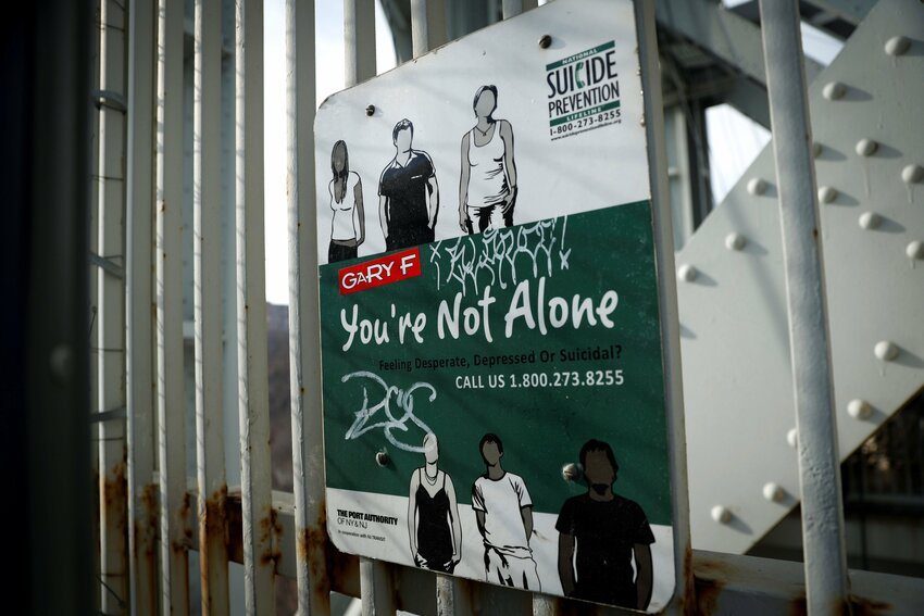 A suicide prevention sign is pictured on a protective fence on the walkway of the George Washington Bridge between in New York City Jan.12, 2022. The suicide epidemic in the U.S. is costing lives, and Catholic dioceses and ministries are racing to get in place much needed accompaniment for those crying for mental health help.