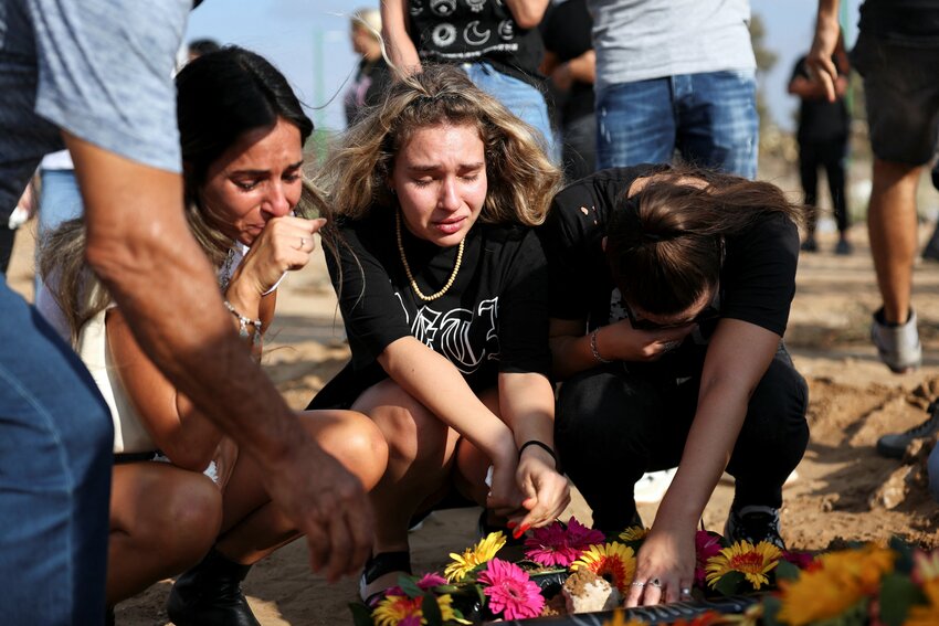 People mourn at the graveside of Eden Guez, during her funeral in Ashkelon, i Israel, October 10, 2023, who was killed as she attended a festival that was attacked by Hamas gunmen from Gaza. Israel increased airstrikes on the Gaza Strip and sealed it off from food, fuel and other supplies Monday in retaliation for a bloody incursion by Hamas militants, as the war&rsquo;s death toll rose to nearly 1,600 on both sides. Hamas also escalated the conflict, pledging to kill captured Israelis if attacks targeted civilians without warnings.