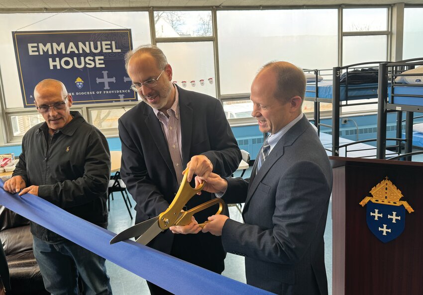 State Housing Secretary Stefan Pryor, center, assists Jim Jahnz, secretary of Catholic Charities and Social Ministries, in cutting the ribbon marking the official opening of the new women&rsquo;s shelter Emmanuel House, as Shelter Manager Mike Marzullo looks on.