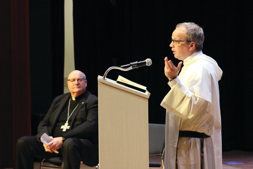 Local faithful and clergy gather at McVinney Auditorium as Father Thomas Joseph White, O.P., speaks of the current ideological and cultural challenges to living the Catholic faith, with Bishop RIchard G. Henning looking on.