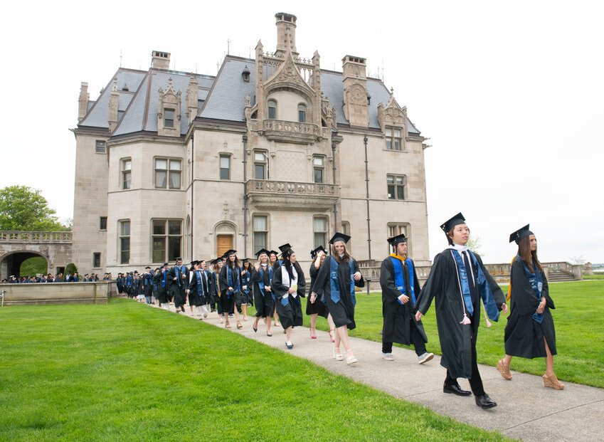 Salve Regina University graduates process past Ochre Court as they make their way on campus to the 74th Commencement in Newport.