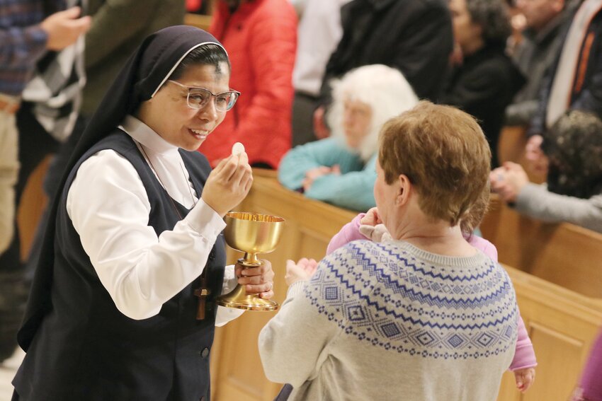 In this file photo, Sister Elizabeth Castro, H.M.S.P., director of the Office for Religious for the Diocese of Providence and a member of the Missionary Sisters Servants of the Word, distributes communion on Ash Wednesday at the Cathedral of SS. Peter and Paul, Providence.