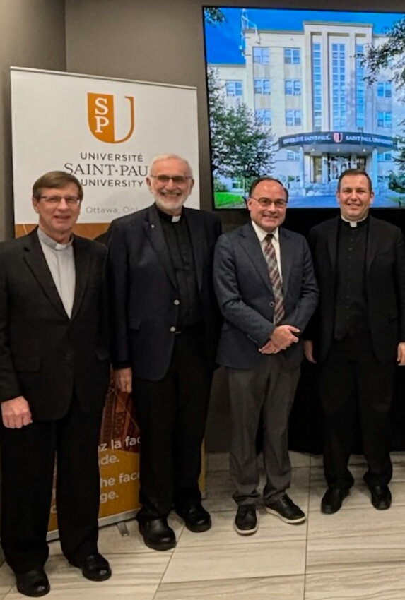 Father Albert P. Marcello III, J.C.D./Ph.D, at right, is joined by, from far left, Father Wojciech Kowal, OMI; Msgr. John Renken; and Saint-Paul University Dean Chad Glendinning, during Father Marcello’s doctoral thesis defense on November 25, 2024.