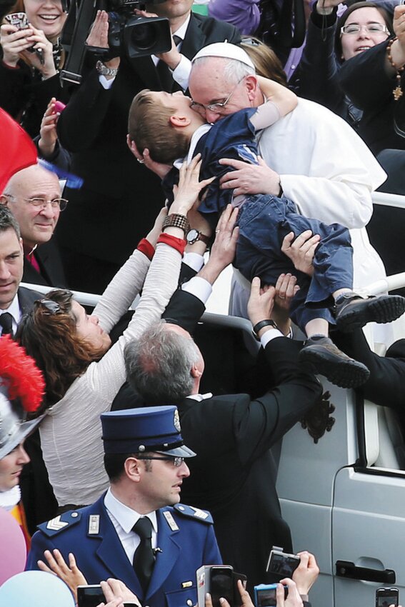 Our Lady of Grace Parish, Johnston, parishioner Christiana Gondreau, left, assisted by Augustino, a Vatican usher, holds her 8-year-old son Dominic as he is embraced by Pope Francis in St. Peter’s Square following his first Easter Mass on Sunday, March 31, 2013. Dominic, who has cerebral palsy, is also the son of Providence College faculty member Dr. Paul Gondreau.