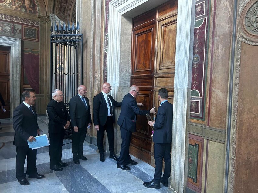 Ranking officers of the Vatican police and the Pontifical Swiss Guard place a beaded rope and seal on a Vatican office in the Apostolic Palace May 6, 2025. Buildings along the path cardinals may take from their residence to the Sistine Chapel during the conclave to elect a new pope have been sealed off.