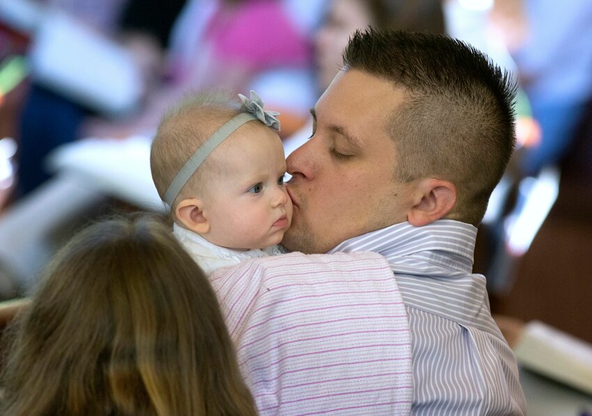 A man kisses his daughter during Mass in 2014 at Jesus the Divine Word Church in Huntingtown, Md. Father's Day, an annual observance honoring fathers and celebrating fatherhood, falls on June 15, 2025, this year.  (OSV News photo/Bob Roller)