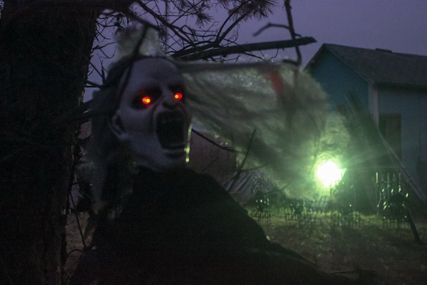 A decoration in the Country Bumpkins graveyard hangs by a tree and its eyes flicker red.