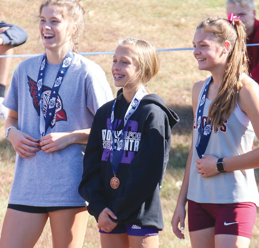 Lilly Kenning of Milford stands with the other medal winners after the Class C girls' state cross country race Oct. 22.