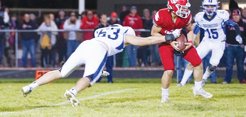 Sam Payne of Centennial (63) tries to bring down the Ord ballcarrier as Lance Haberman (15) comes in to help Oct. 29.