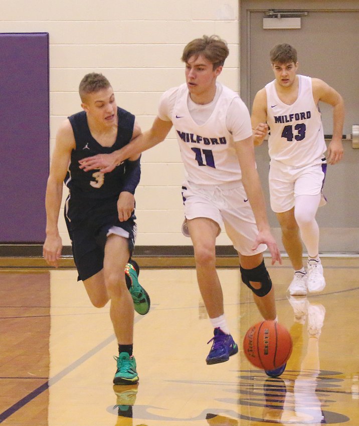 Milford's Micah Hartwig tries to keep Logan DeBoer of Lincoln Lutheran away from the ball as they come down the court Dec. 11. MHS's Seth Stutzman trails the play.