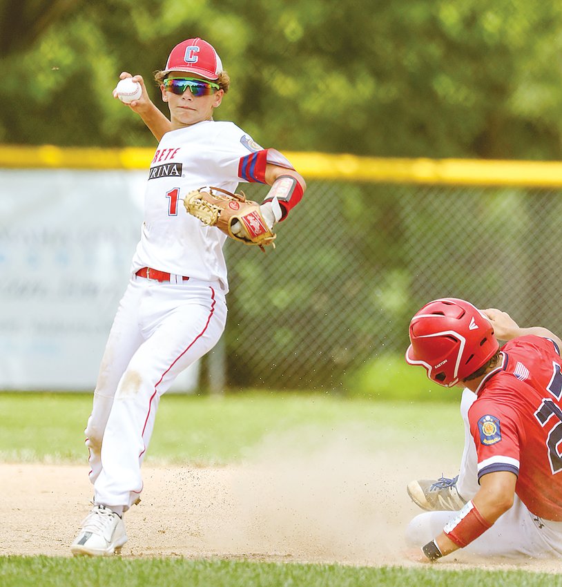 Crete second baseman Patton Svitak tries to turn a double play during junior Legion district tournament play in Auburn July 9.