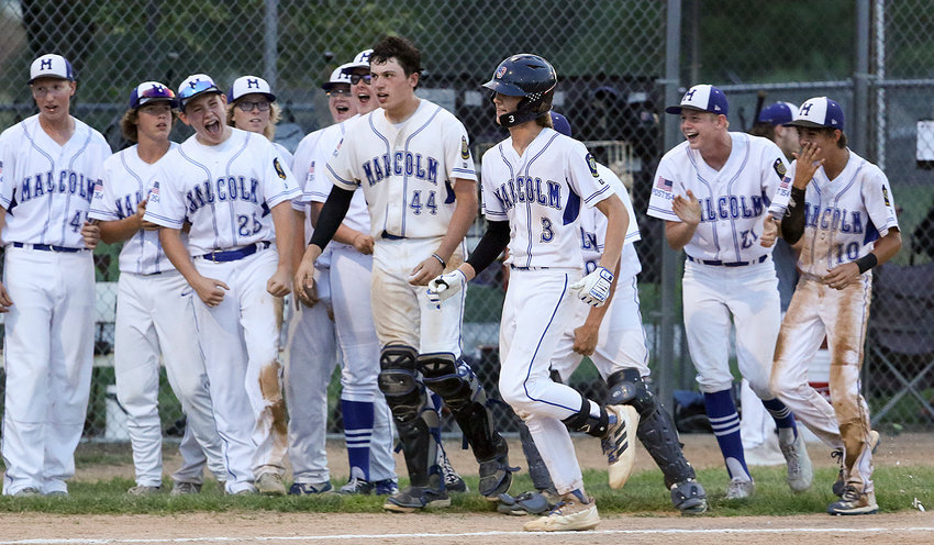 The Malcolm junior legion baseball team celebrates Maddox Meyer's (center) three-run home run in the seventh inning against Syracuse Sunday nightthat tied the game 3-3. Malcom ended up winnng the game 4-3 in extra innings.