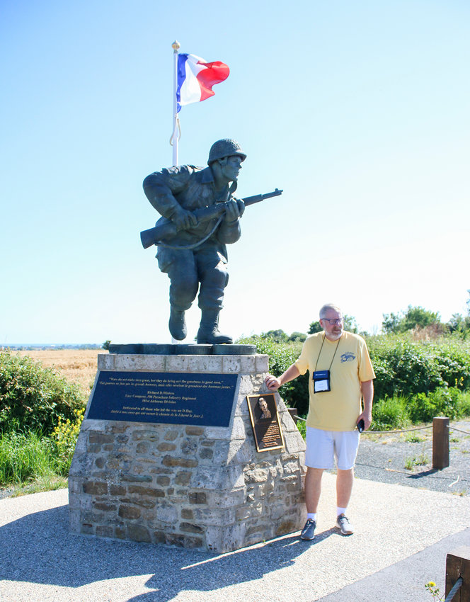 Jerry Meyer leaves an Airborne token at the Dick Winters statue near Utah Beach.