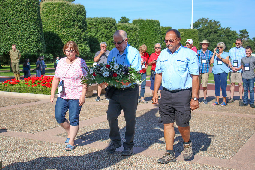 From left, Sue Stahr, Dick Breuer and Jerry Stahr lay a wreath at Normandy American Cemetery.