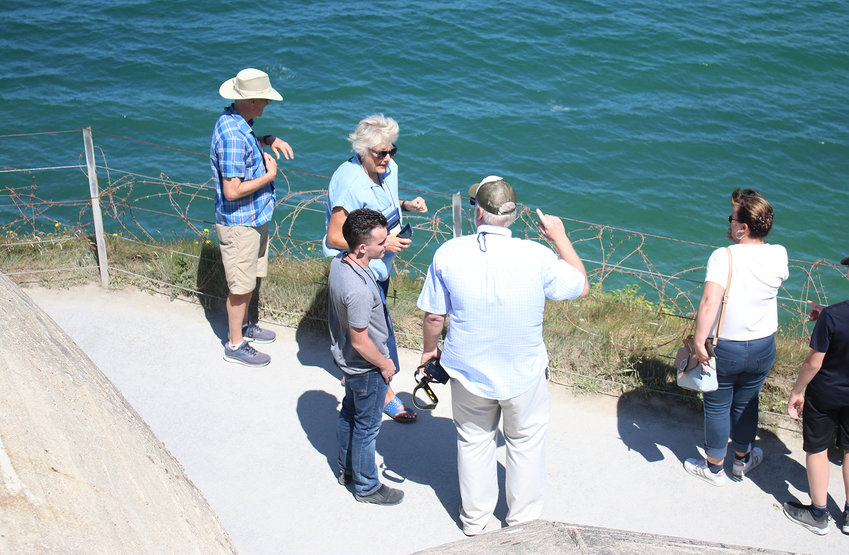 Jerry Meyer makes a point as Jeff and Trudy Hines and Nick Tuma listen at Pointe du Hoc.