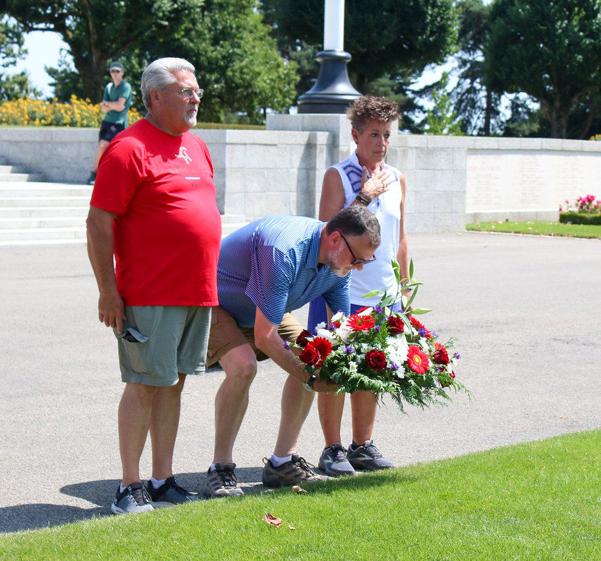 From left, Wayne Milton, Darren Krueger and Lori Milton lay the wreath at the Brittany American Cemetery July 17.