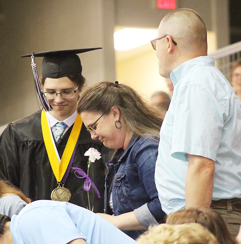 Milford salutatorian Nolan Eickhoff gives a flower and a hug to his parents, Jennifer and Karl Eickhoff, during MHS' commencement May 13. Nolan reflected on the seniors’ tumultuous four years of high school during his address. The class lost part of its freshman year as the COVID-19 pandemic ramped up in 2020, and it was in kindergarten when the school adopted its district-wide theme, “Everyone has a story…make yours worth telling.” “Every story has a bad part. Every story has a downfall. That’s what makes your story worth telling,” he said.