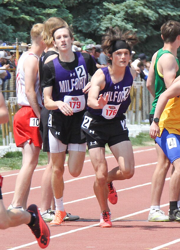 Hudson Mullet, left, hands the baton to Kaleb Eickhoff in the 4x800-meter relay May 19.