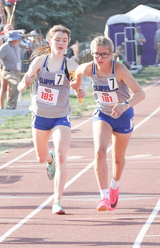 Samantha Back of Malcolm, right, takes the baton from teammate Rachel Lannin in the 4x400-meter relay May 20.