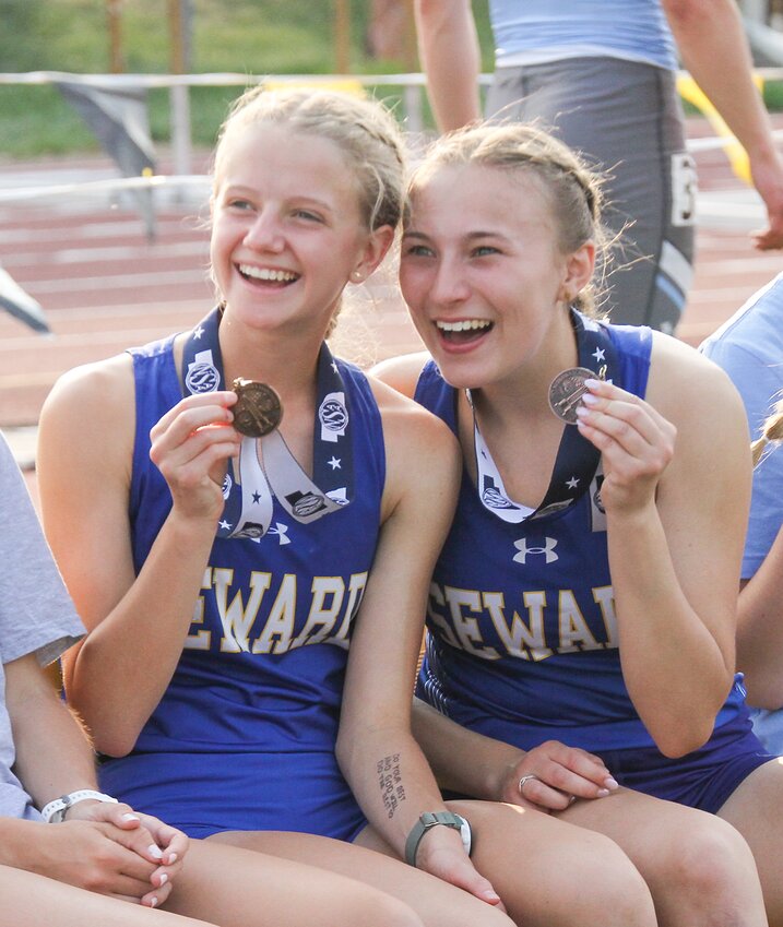 Tessa Greisen, left, and Karnie Gottschalk show their 3,200-meter run medals for a photo before the medal ceremony May 17.