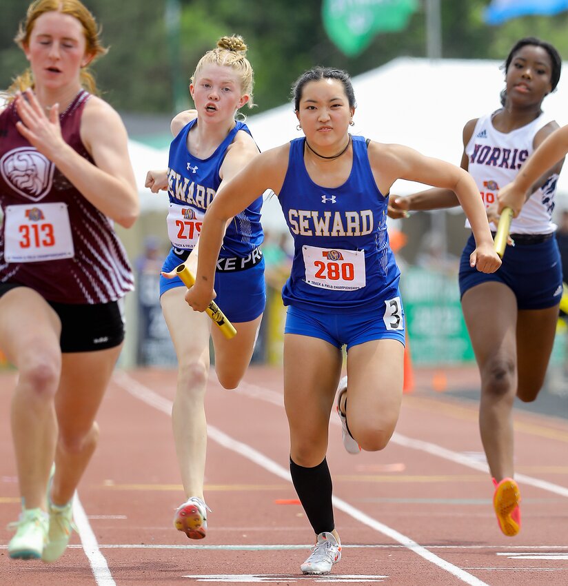 Vicki Wang of Seward takes the baton from Eden Schulz in the 4x100-meter relay May 18.