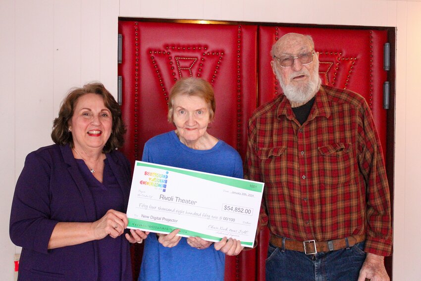 Jeanne Wiemer, president of the Seward Arts Council, presents Julie and Chuck Wisehart with a check for a new projector on Jan. 26