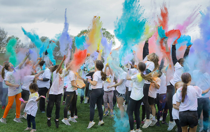 Participants in Milford High School's color run fundraiser April 25 toss colored powder into the air following  the event.