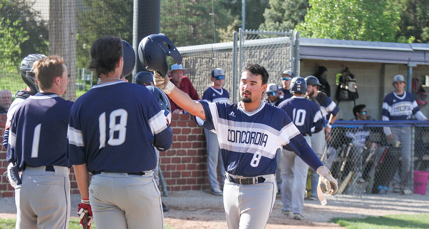 Jayden Adams of Concordia receives congratulations from teammates after hitting a home run in game one against Midland May 4.