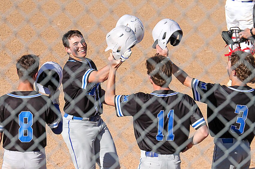 It's all smiles for Mason Wisnieski as he's congratulated by teammates Chase Smith (8), Maddox Meyer (11) and Brixon Meyer (3) after hitting a grand slam May 3.