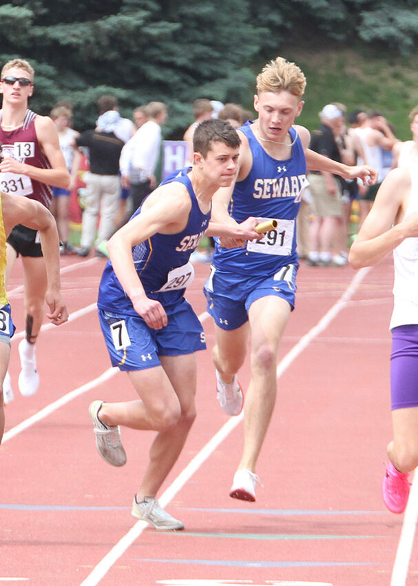 Seward's Micah Royuk takes the baton from Kameron Dyer in the boys' 4x800-meter relay.