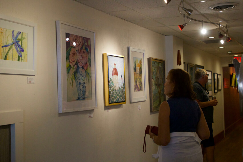 Sue King admires the art of various artists, including mosaic fabric art of the Seward Courthouse done by Pam Apley inside the Red Path Gallery and Tasting Room.