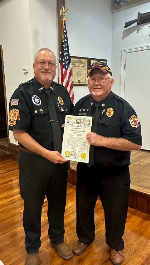 Curt Deremer presents Bill Deremer, a 55-year volunteer with the Utica Volunteer Fire and Rescue Department, with an Admiral of the Great Navy certificate. 