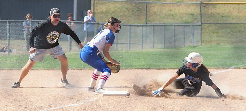 Lauren Frihauf of Seward beats the tag at third as Coach Shawn Carr moves into position for a closer look during Seward's semifinal loss to Crete Oct. 3.