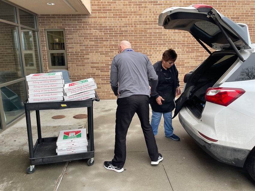 PIzza Kitchen staff unload boxes of pizza at Milford Jr./Sr. High School Jan. 24.