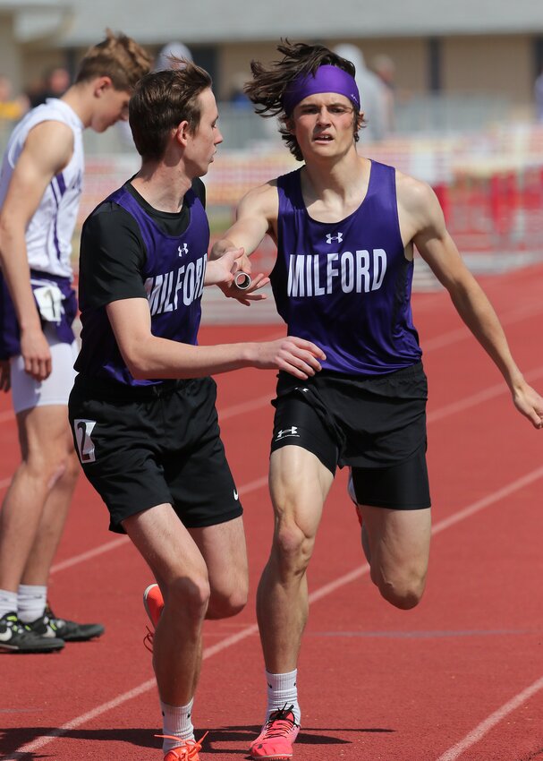 Milford's Kaleb Eickhoff hands off to anchor leg Hudson Mullet in the 3,200-meter relay at Centennial April 18.