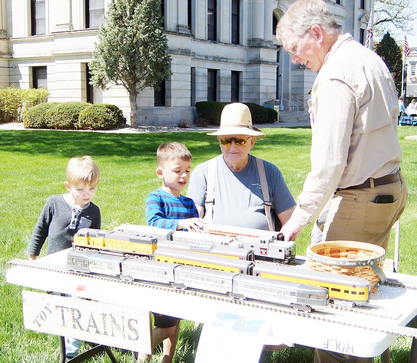 From left, Oliver Uden and Jaxon Bales learn about O gauge model trains from Merlin Berg and Gary Rolf at the Model Train Club of Seward County