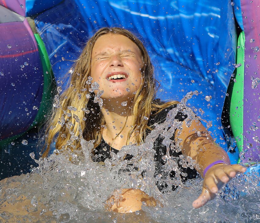 Twelve-year-old Dakota Cunningham of Milford reaches the bottom of the waterslide during Mlford's Fun Days August 19.