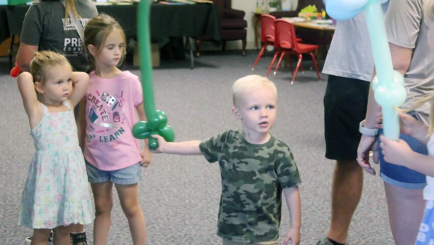 Boden Rohrig, 3, of Pleasant Dale enjoys his balloon sword. Face painting, a book fair, a meal and more were part of the event, which allowed parents and kids to meet the preschool staff and socialize before the beginning of school.
