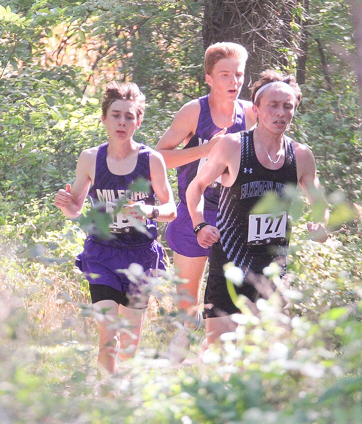 Avery Carter, left, and Gavin Dunlap, back, of Milford run through the trees on the course at the Charlie Thorell Invitational in Seward Aug. 31.