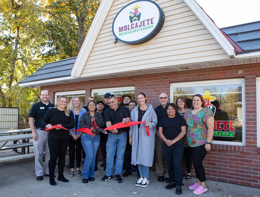 Yraisa Lopez, with thee scissors, and her husband Jaime Lopez, to her right, does the honor with staff and members of the Milford Chamber of Commerce at  a ribbon cutting for the Lopez's Molcajete Mexican Restaraunt in Milford Tuesday morning.