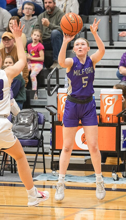 Kylie Jakub of Milford takes a shot as the Minden defender closes in Feb. 23.