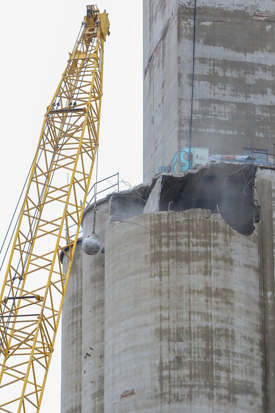 Workers use a wrecking ball to begin tearing down an old, unused grain elevator in downtown Milford March 25.