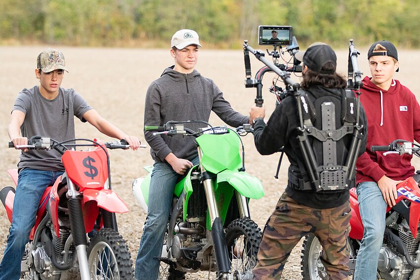 Milford residents Cash Dickinson, Connor Adams and Gavin Dunlap are filmed on dirt bikes as part of the filming for a country music video last October just outside of Milford.