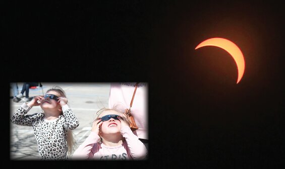 Seward wasn’t in the path of totality for the 2024 solar eclipse, but the moon covered about 80% of the sun for viewers here April 8. Left, Zoe Wortmann, 5, and Aviva Gauthier, 4, look at the eclipse with their eclipse glasses.