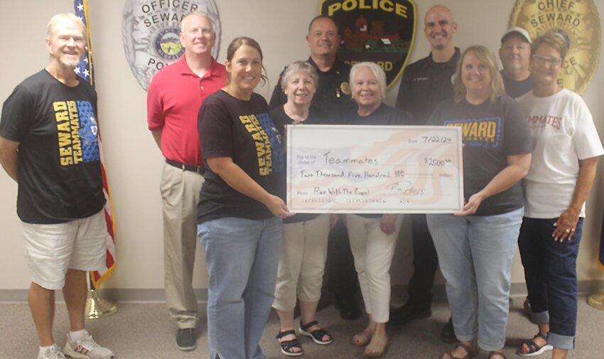 Members of Seward TeamMates were presented with a check July 22 with funds raised by the Seward Police Department from the Run with the Cops 5K. Shown are, from left: (front row) TeamMates representatives, Sarah Rodocker, Juanita Hill,  Sandy Wright, Kelly Kimbrough and Deb Sloup; and (back row) Steve Borer, Josh Fields, Police Chief Brian Peters, officer Chris Waldron and Rick Gray.