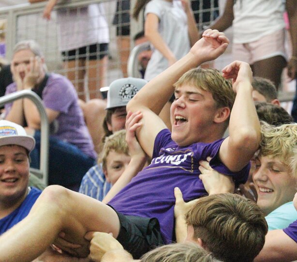 Milford students send Quinn Zegers to the top of the student section and back during the Milford/Seward volleyball match Aug. 29.