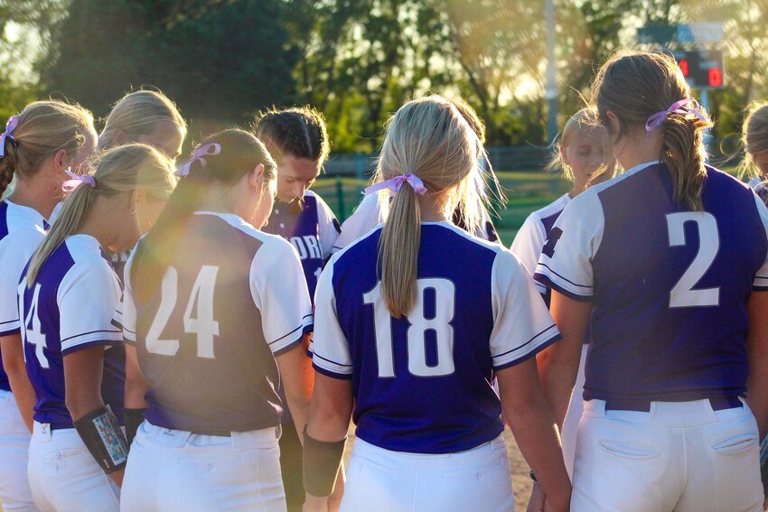 The Milford softball team prays before its game against Crete at home on Sept. 24.