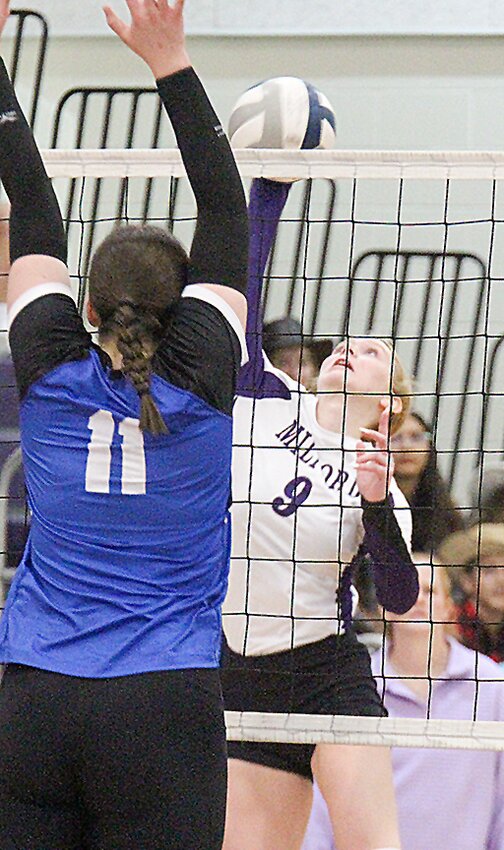 Shayla Rautenberg (11) and Sarah Reynolds (15) of Milford put up a block against Centennial's Natalie Sams Oct. 1.