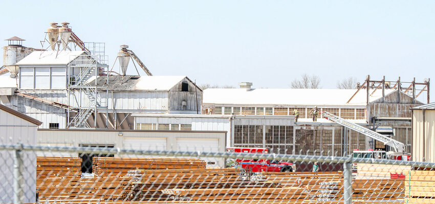 Firefighters were still on scene at Hughes Brothers in Seward at 2:50 p.m. April 17, following a fire that damaged one of the company's buildings, pictured left with the blackened roof.